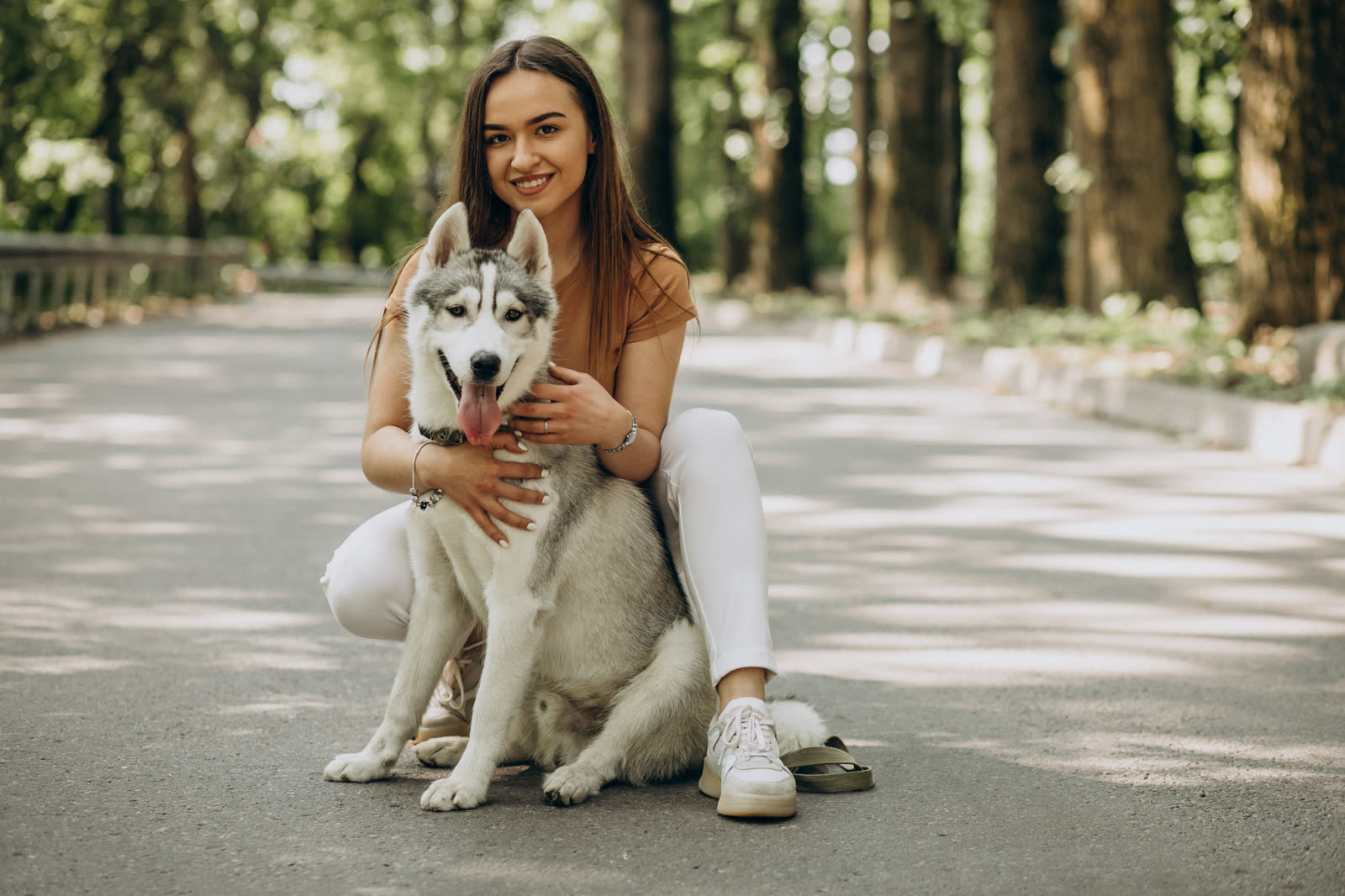 Mulher sentada em um parque com seu cão husky